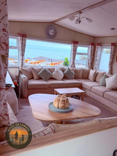 a living room with a couch and a table at 3 Bedroom Caravan with stunning panoramic sea view in New Quay