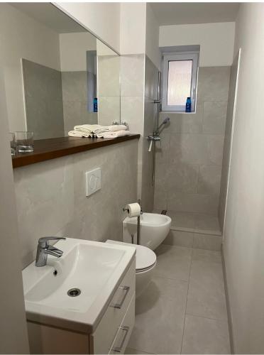 a white bathroom with a sink and a toilet at RRR Apartmány 5 in Bojnice