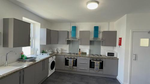 a kitchen with a sink and a stove top oven at Esk View House,Carlisle in Carlisle