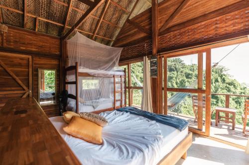 a bedroom with a bed in a room with windows at Paraiso Ahimsa in Buritaca