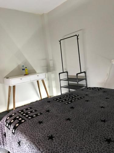 Schlafzimmer mit einem Bett mit einem Tisch und einem Spiegel in der Unterkunft Habitación en el corazón de Chiclayo in Chiclayo