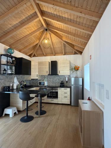 a kitchen with wooden ceilings and a table and chairs at Villa Barbosa in Quintiães