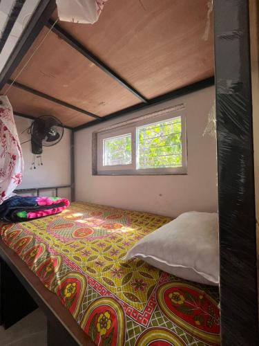 a bed in a small room with a window at Mahaveer Lodge in Siliguri