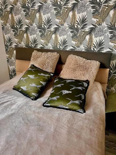 a bed with two pillows on it with a wall at Here comes the sun in Batumi