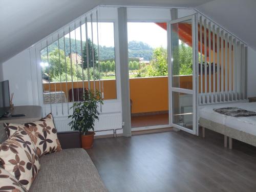 a living room with a couch and a large window at Casa Ildikó in Sovata