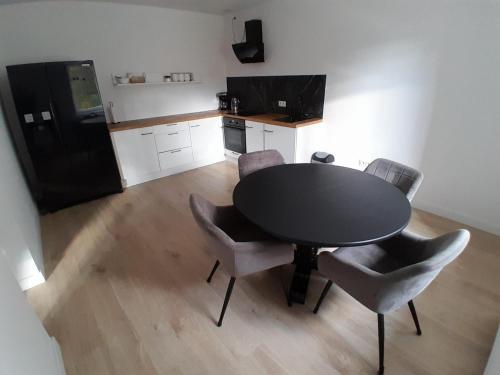 a kitchen with a table and chairs and a black refrigerator at U Mariki 