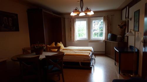 a room with a bed and a table and a window at Landgasthof Pension Schützenhaus in Dürrhennersdorf