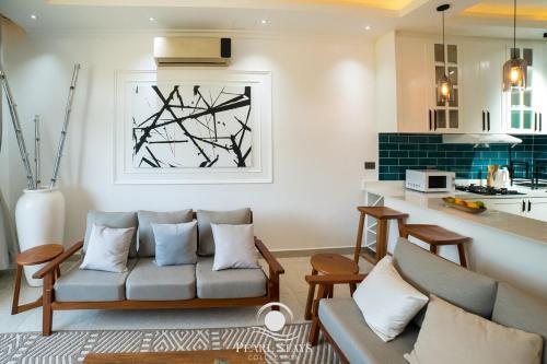 a living room with a couch and a kitchen at Lakeside Serenity Stylish 2BR Getaway - Entebbe in Entebbe