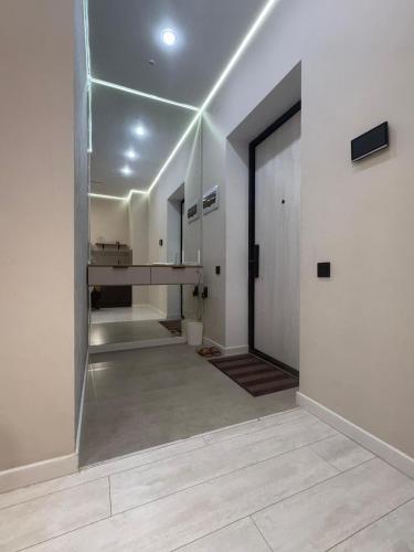 ein leeres Zimmer mit Flur mit Glastür in der Unterkunft Comfort Studio Apartment in Almaty