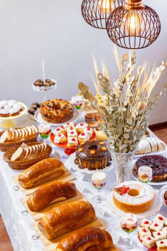 een tafel met veel verschillende soorten gebak bij Pousada Valle das Flores Monte Verde in Monte Verde