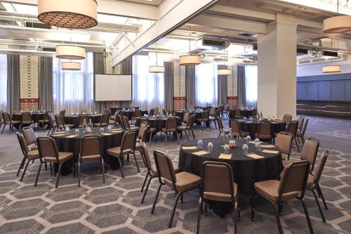 a conference room with tables and chairs and a screen at Kimpton Clocktower by IHG in Manchester