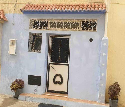 a blue building with a door with a hat on it at Casa Inas in Chefchaouene