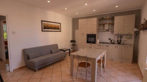 a kitchen and living room with a couch and a table at Spazioso appartamento vicino a tutto in Tortona