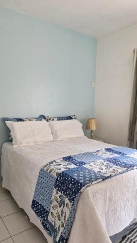 a bed with a blue and white blanket on it at Locação por Temporada e Cop 30 in Ananindeua