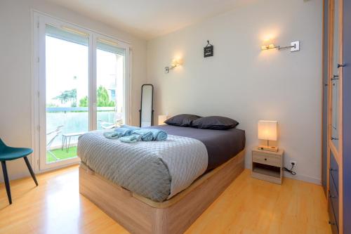 a bedroom with a bed and a large window at Les jardins de Rangueil, Parking, Métro, Piscine in Toulouse