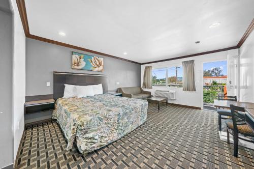 a hotel room with a bed and a desk at Starlight Inn South El Monte in South El Monte