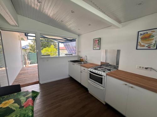 a kitchen with white cabinets and a stove top oven at Ti Belcourt in Baie-Mahault