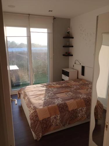 a bedroom with a bed and a large window at Appartement Béhobie in Urrugne