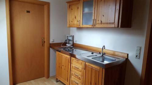 a kitchen with a sink and wooden cabinets at Landgasthof Pension Schützenhaus in Dürrhennersdorf