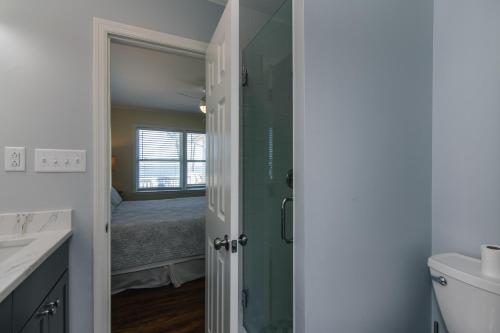 Un baño con ducha y un dormitorio con cama. en Beach Blessing, en Edisto