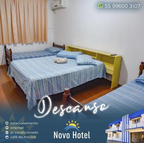 two beds in a room with a advert for novo hotel at Novo Hotel in Caçapava do Sul