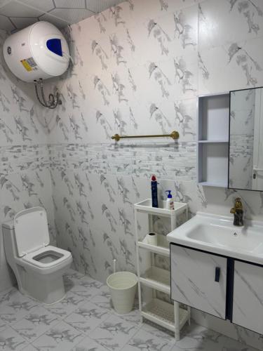 a bathroom with a white toilet and a sink at استرحه ام الحمام in Suḩaybah