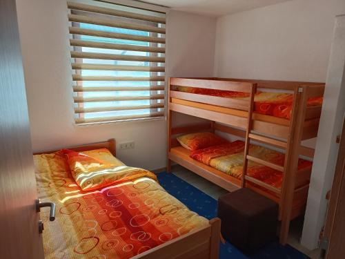 a bedroom with two bunk beds and a window at Apartmani Vila Alpe in Travnik