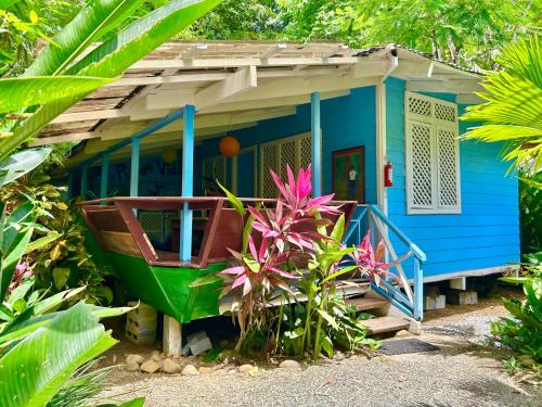 a blue house with a boat in front of it at Ita Ita Casitas Playa Punta Uva in Punta Uva