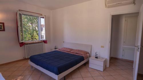 a bedroom with a blue bed and a window at Spazioso appartamento 2 in Tortona