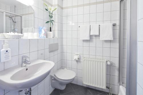 ein weißes Badezimmer mit Waschbecken und Toilette in der Unterkunft Hotel Sonnenblick Bebra in Bebra