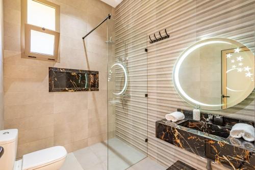 マラケシュにあるVilla Kamélia 5000m Hammam Piscine Chauffée et Sans Vis à Visのシャワー、洗面台、鏡を備えたバスルーム