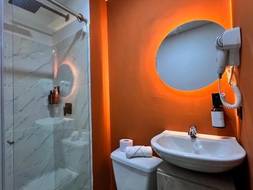 a bathroom with a toilet and a sink and a mirror at Hermoso y cómodo ambiente para grupos 104-105 in Medellín