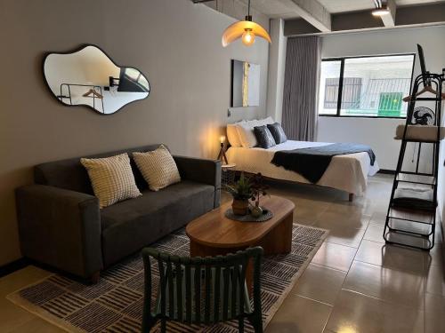 a living room with a couch and a bed at Hermoso y cómodo ambiente para grupos 104-105 in Medellín