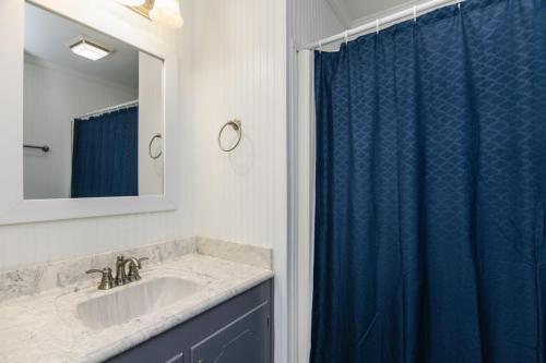 a bathroom with a sink and a blue shower curtain at Sutton House in Edisto Island