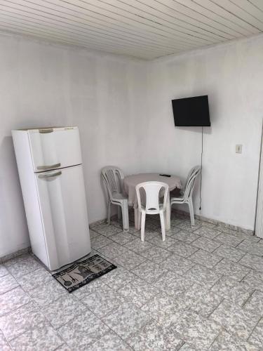a kitchen with a table and a white refrigerator at Apartamento Central in Primavera do Leste