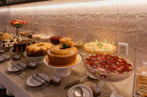 a table with many different types of cakes and pies at Hotel Pirá Miúna in Bonito