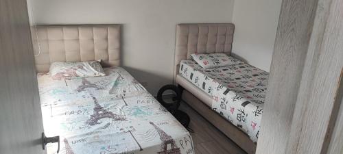 two beds in a small room at Departamento Completo Hacienda Peñalisa - Ricaurte in Ricaurte