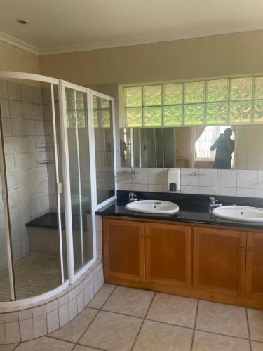 a bathroom with two sinks and a large mirror at Gugu's Holiday Home in Durban