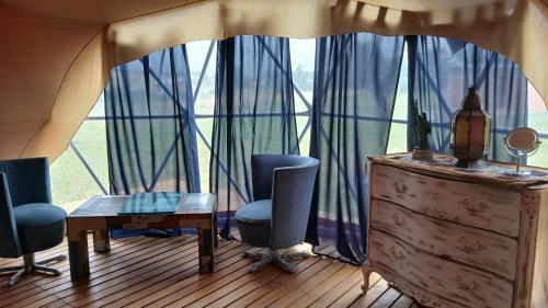 a room with a table and chairs and a large window at Domo Naranja in Miramar