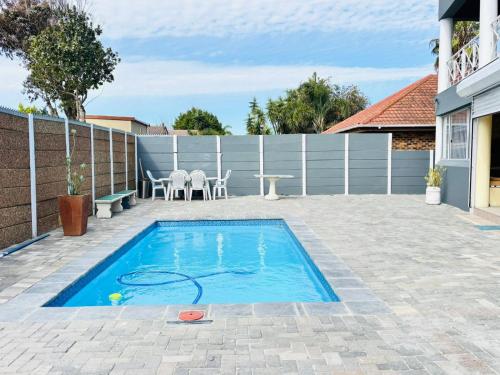una piscina en un patio trasero con una mesa en KBJ House, en Ciudad del Cabo