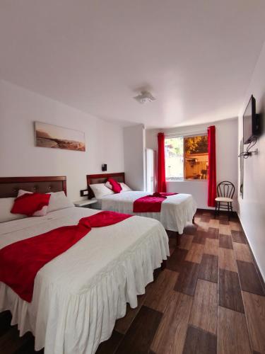 a hotel room with three beds with red curtains at Casa Gaviota Dorada in Baños