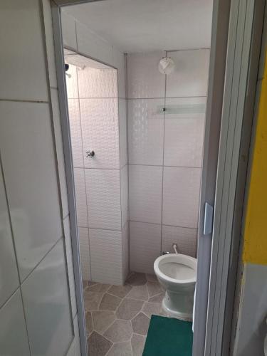 a small bathroom with a toilet and a shower at Casa da Lia in Lençóis