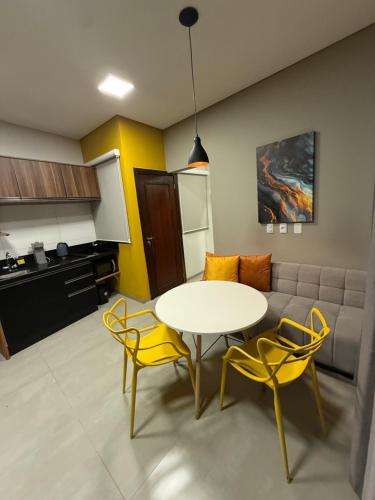 a living room with a table and chairs and a couch at Loft com 2 Qts e garagem em área nobre in Sinop