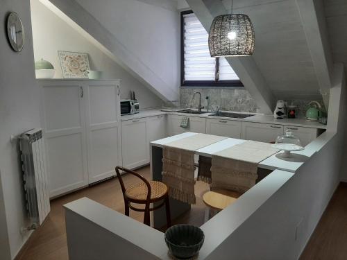 a kitchen with white cabinets and a table and chairs at La Fenice in Mortara