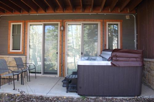 a screened in porch with a bed and patio furniture at Alpenglow Ski n Ski Out with Amazing Views in Durango Mountain Resort