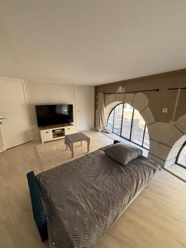 a bedroom with a large bed with a large window at TheNest in Vienne