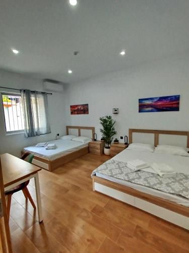 two beds in a large room with wooden floors at Leonidio Downtown Haven in Leonidio