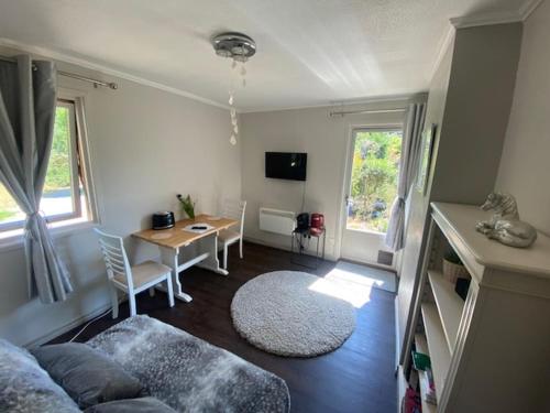 a living room with a table and a dining room at Carpenters-stay in Dorking