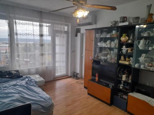 a room with a bed and a book shelf with cups at Dayana in Varna City