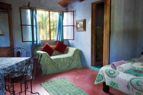 a bedroom with a bed and a window and a table at Casa Poesía Sayulita in Sayulita